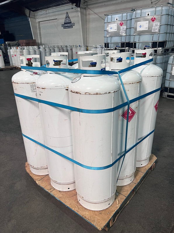 Empty cylinders on a pallet, banded around the outside with a vertical strap through the pallet